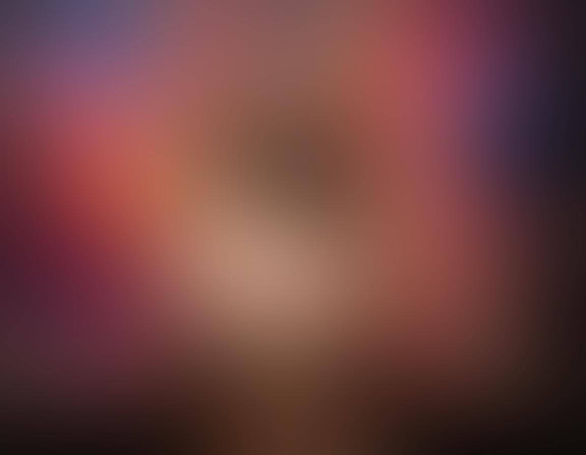 A captivating scene featuring a confident, busty performer in a sultry pose, surrounded by artistic elements like paintbrushes, canvas, and vibrant colors splashing around. The background should evoke a sense of intimacy and creativity, with soft lighting enhancing her allure. Include subtle hints of adult themes through tasteful expressions and props, all while celebrating the artistry and individuality of solo adult content. super-realistic. vibrant colors. artful composition.